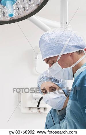 Surgeons performing a surgery in an operating room View Large Photo Image Stock Image - Surgeons performing a surgery in an operating room. Fotosearch