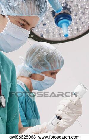 Surgeons performing a surgery in an operating room View Large Photo Image Stock Photo - Surgeons performing a surgery in an operating room. Fotosearch