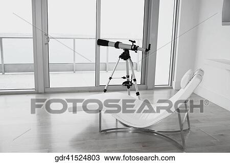 Telescope with a lounge chair in a room View Large Photo Image Stock Image - Telescope with a lounge chair in a room. Fotosearch