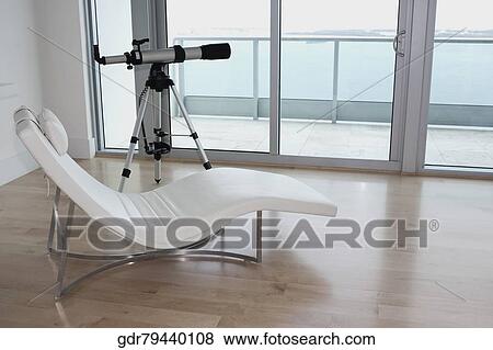 Telescope with a lounge chair in a room View Large Photo Image Stock Photo - Telescope with a lounge chair in a room. Fotosearch