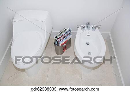 Stock Image - Toilet bowl with bathroom sink in the bathroom. Fotosearch