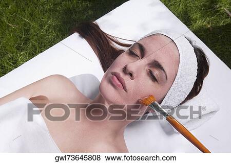 Woman applying a facial mask View Large Photo Image Stock Photo - Woman applying a facial mask. Fotosearch