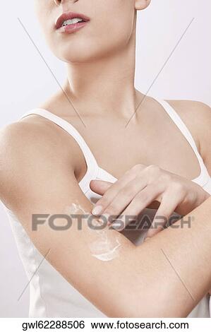 Stock Photograph - Woman applying moisturizer cream on her arm. Fotosearch