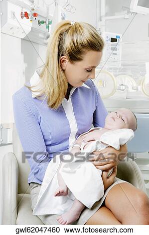 Woman carrying her newborn baby View Large Photo Image Stock Image - Woman carrying her newborn baby. Fotosearch