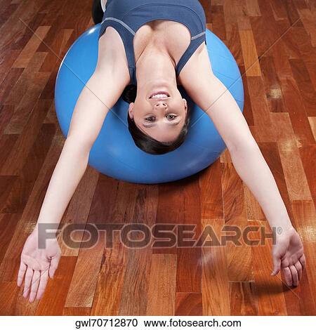 Woman doing sit-ups on a fitness ball View Large Photo Image Stock Image - Woman doing sit-ups on a fitness ball. Fotosearch