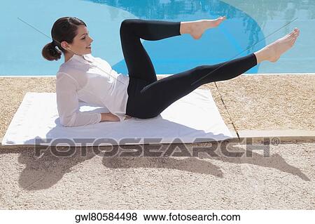 Woman exercising at the poolside View Large Photo Image Stock Photo - Woman exercising at the poolside. Fotosearch