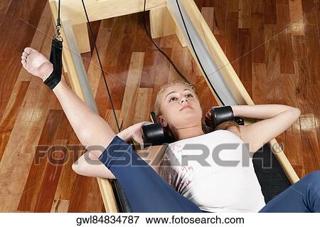 Stock Photo - Woman exercising in a gym. Fotosearch
