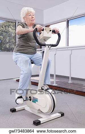 Picture - Woman exercising on exercise bike. Fotosearch