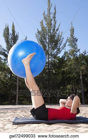 Woman exercising with a fitness ball on the beach View Large Photo Image Stock Image - Woman exercising with a fitness ball on the beach. Fotosearch