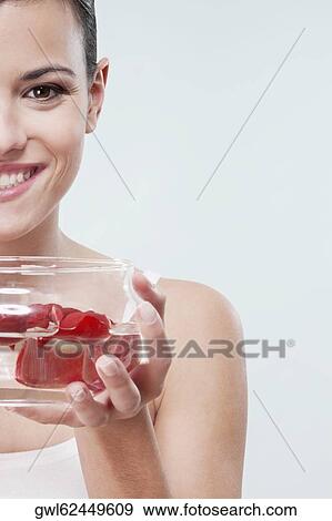 Stock Photo - Woman holding a bowl of rose petals. Fotosearch