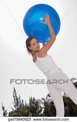 Woman holding a fitness ball View Large Photo Image Stock Image - Woman holding a fitness ball. Fotosearch