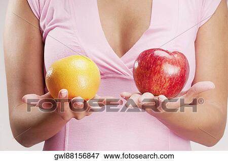 Woman holding an apple and an orange View Large Photo Image Stock Photo - Woman holding an apple and an orange. Fotosearch