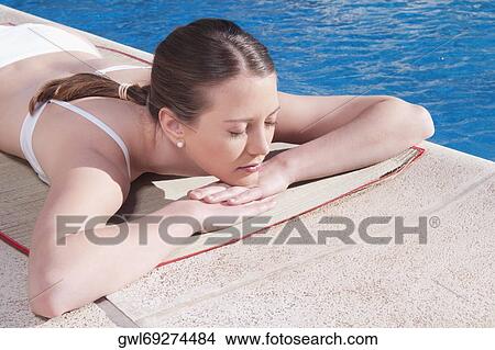 Woman lying at the poolside View Large Photo Image Picture - Woman lying at the poolside. Fotosearch