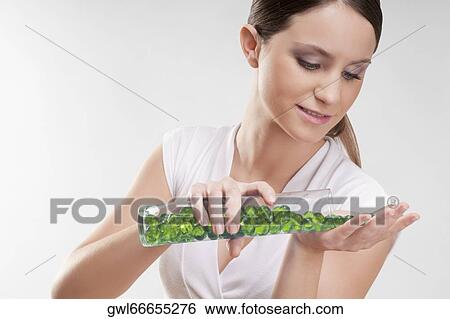 Woman pouring bath beads on her palm View Large Photo Image Stock Photograph - Woman pouring bath beads on her palm. Fotosearch