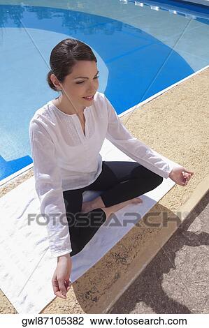 Woman practicing yoga at the poolside View Large Photo Image Stock Image - Woman practicing yoga at the poolside. Fotosearch