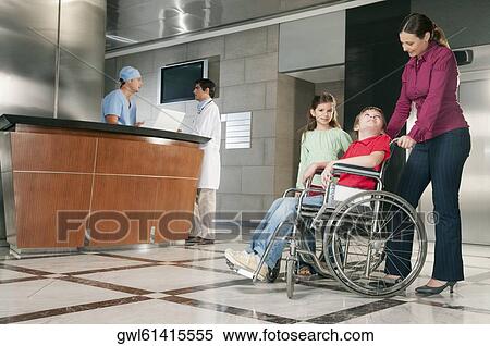 Stock Photography - Woman pushing her son in a wheelchair. Fotosearch