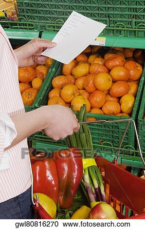 Woman shopping vegetables in a supermarket View Large Photo Image Stock Image - Woman shopping vegetables in a supermarket. Fotosearch