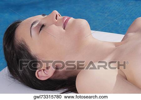 Stock Image - Woman sunbathing on a massage table. Fotosearch