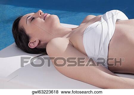 Stock Photo - Woman sunbathing on a massage table. Fotosearch