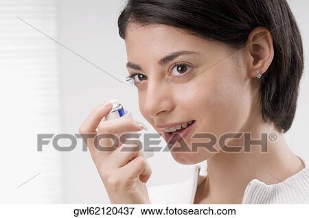 Woman using an asthma inhaler View Large Photo Image Stock Photo - Woman using an asthma inhaler. Fotosearch