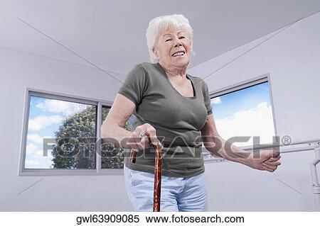 Stock Photography - Woman walking with a cane. Fotosearch