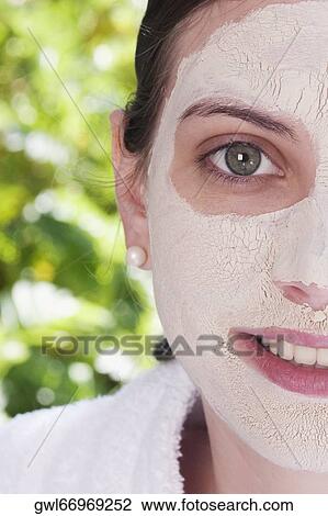 Stock Image - Woman with facial mask on her face. Fotosearch