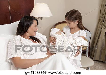 Woman with her newborn baby and daughter in a hospital View Large Photo Image Stock Photograph - Woman with her newborn baby and daughter in a hospital. Fotosearch