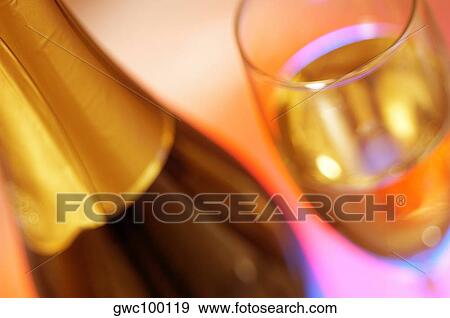 Close-up of a champagne bottle with champagne in a champagne flute View Large Photo Image Stock Photo - Close-up of a champagne bottle with champagne in a champagne flute. Fotosearch