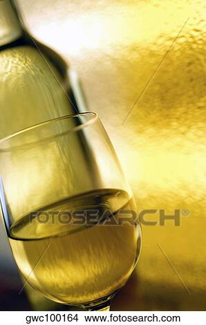 Picture - Close-up of a glass of wine in front of a wine bottle. Fotosearch