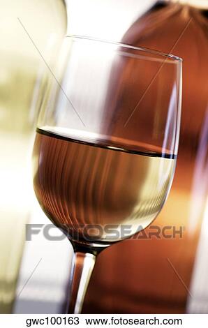 Close-up of a glass of wine in front of two wine bottles View Large Photo Image Stock Image - Close-up of a glass of wine in front of two wine bottles. Fotosearch