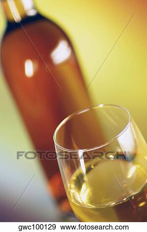 Stock Photo - Close-up of a glass of wine with a wine bottle. Fotosearch