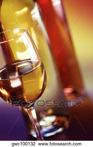 Close-up of a glass of wine with two wine bottles View Large Photo Image Stock Image - Close-up of a glass of wine with two wine bottles. Fotosearch