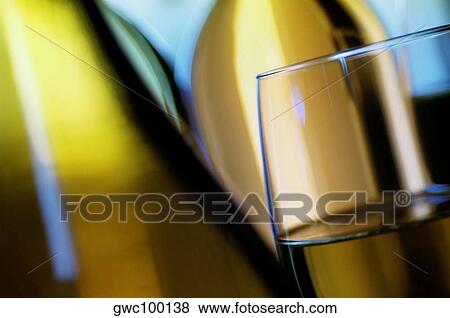 Stock Photo - Close-up of a glass of wine with two wine bottles. Fotosearch