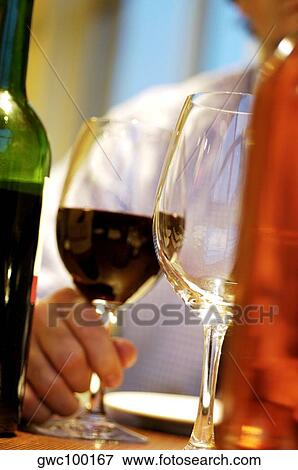 Stock Photo - Close-up of a person's hand holding a glass of wine. Fotosearch