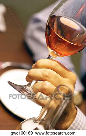 Stock Photo - Close-up of a person's hand holding a glass of wine. Fotosearch
