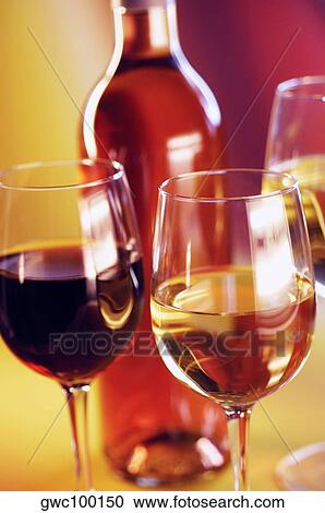 Close-up of three glasses of wine with a wine bottle View Large Photo Image Stock Image - Close-up of three glasses of wine with a wine bottle. Fotosearch