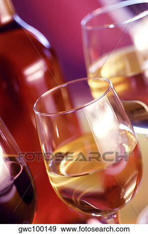Close-up of three glasses of wine with a wine bottle View Large Photo Image Stock Photo - Close-up of three glasses of wine with a wine bottle. Fotosearch