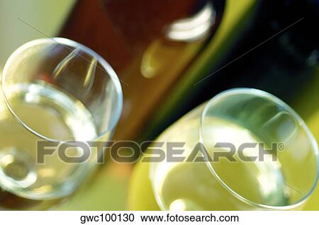 Close-up of two glasses of wine with a wine bottle View Large Photo Image Stock Image - Close-up of two glasses of wine with a wine bottle. Fotosearch