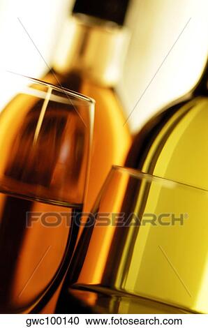 Stock Image - Close-up of two wine bottles with two glasses of wine. Fotosearch