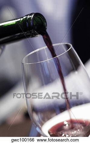 Close-up of wine being poured into a wineglass View Large Photo Image Stock Photograph - Close-up of wine being poured into a wineglass. Fotosearch