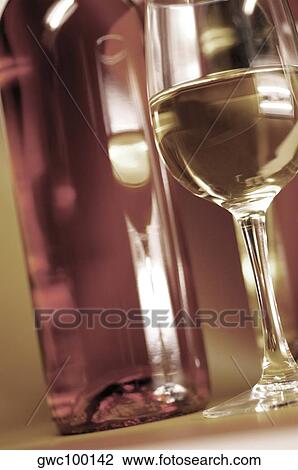 Low angle view of a wine bottle with a glass of wine View Large Photo Image Stock Image - Low angle view of a wine bottle with a glass of wine. Fotosearch