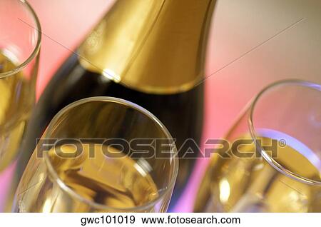 Close-up of a champagne bottle with champagne in three champagne flutes View Large Photo Image Stock Photo - Close-up of a champagne bottle with champagne in three champagne flutes. Fotosearch