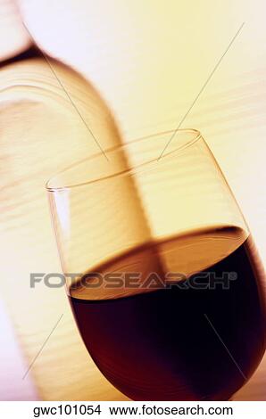 Close-up of a glass of wine with a wine bottle View Large Photo Image Picture - Close-up of a glass of wine with a wine bottle. Fotosearch
