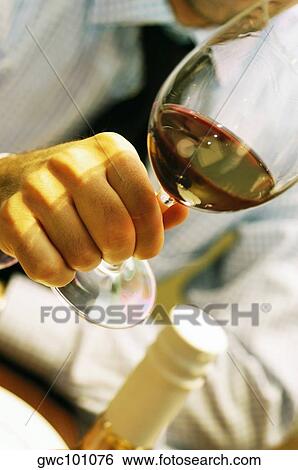 Close-up of a person's hand holding a glass of wine View Large Photo Image Stock Photograph - Close-up of a person's hand holding a glass of wine. Fotosearch