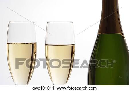 Close-up of champagne in two champagne flutes with a bottle of champagne View Large Photo Image Stock Image - Close-up of champagne in two champagne flutes with a bottle of champagne. Fotosearch