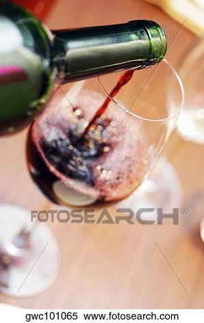 Stock Photography - Close-up of red wine poured into a wineglass. Fotosearch