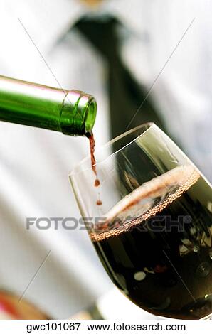 Stock Photo - Close-up of wine being poured into a wineglass. Fotosearch