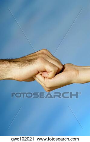 Stock Image - Close-up of a man and a woman holding hands. Fotosearch