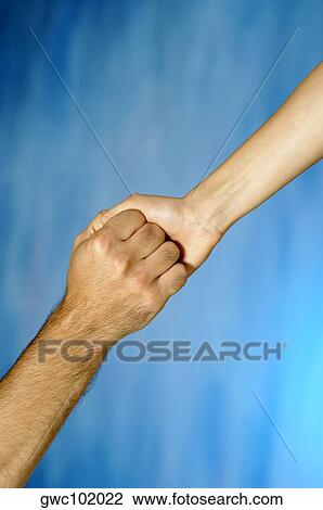 Stock Image - Close-up of a man and a woman holding hands. Fotosearch
