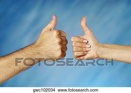 Picture - Close-up of a man and a woman's hands making a thumbs up sign. Fotosearch
